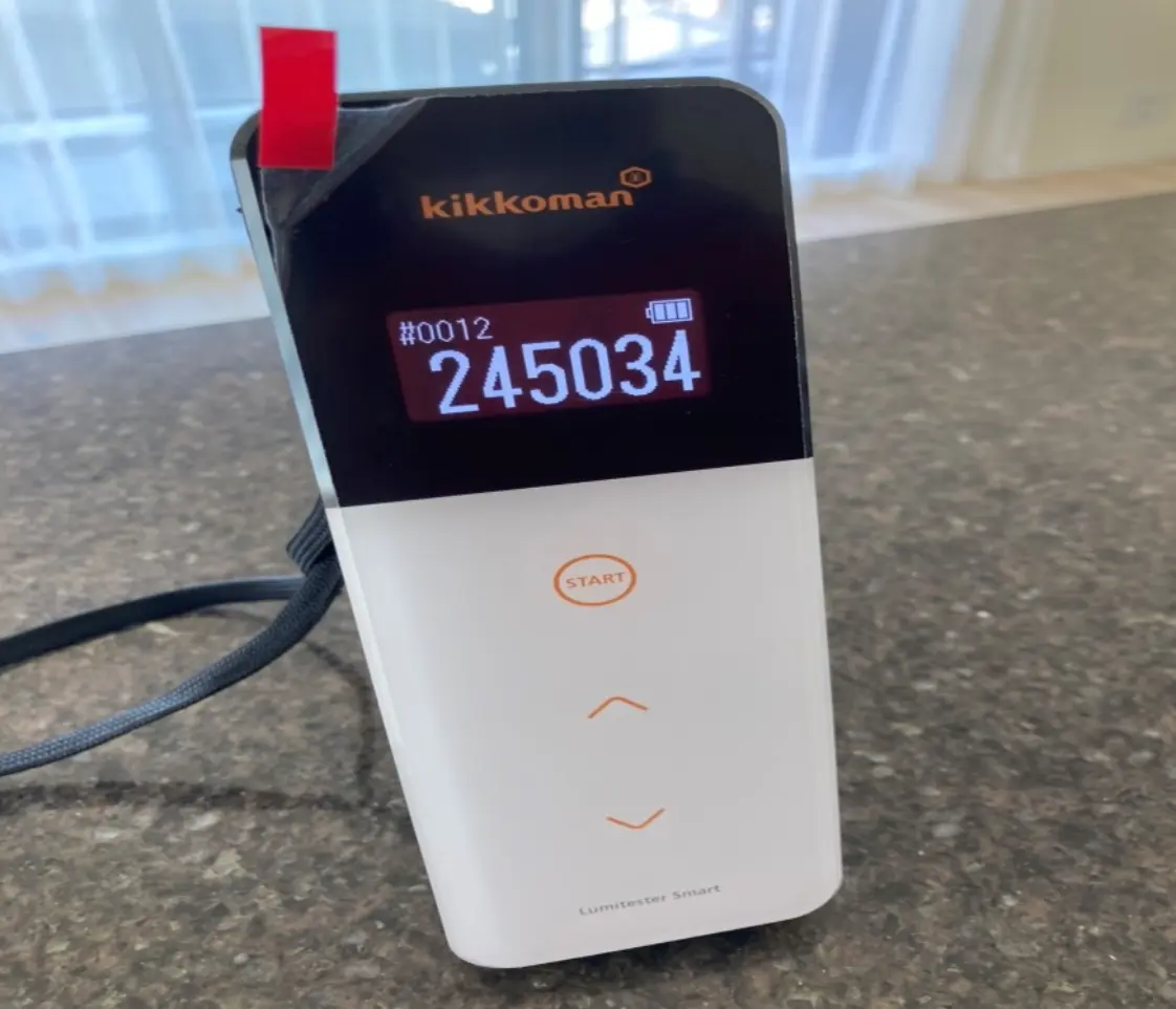 ルミテスターで洗浄前の数値を測定している様子。高い数値が表示されている画面。