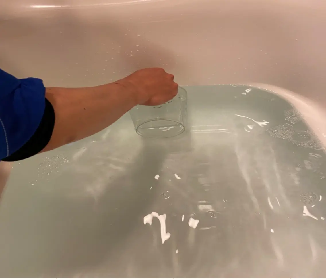 薬剤投入後、白く濁り始めた浴槽の水。